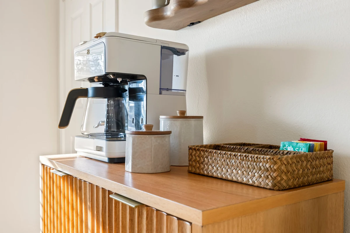 Coffee maker and woven basket on a wooden cabinet